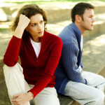 Young Couple Seated Back To Back